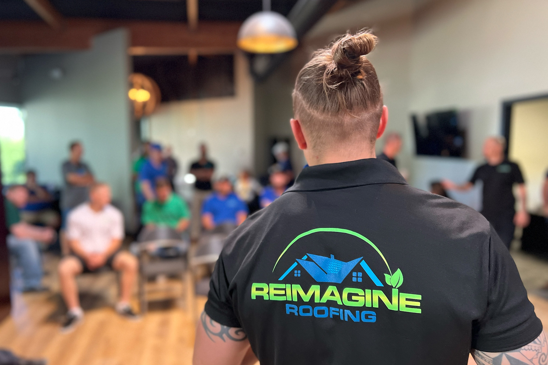 Kody, our CEO, is shown here in a weekly team meeting at Reimagine Roofing, highlighting our company culture with employee shoutouts, incentive contests, and discussions on our book of the month. Kody provides insights on finance and fitness, demonstrating our dedication to the personal and professional development of our team members.
